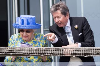 Queen Elizabeth II with her racing manager, John Warren watch the racing from the royal balcony at the Epsom Derby