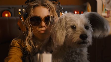 a blonde girl in sunglasses and her white dog