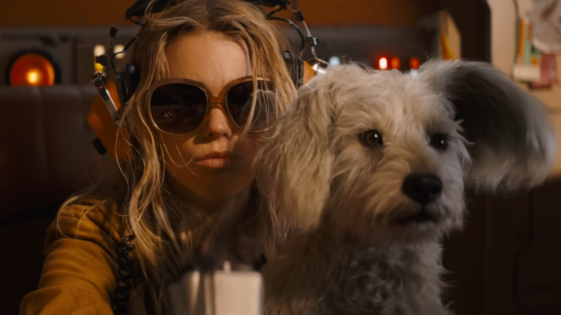 a blonde girl in sunglasses and her white dog