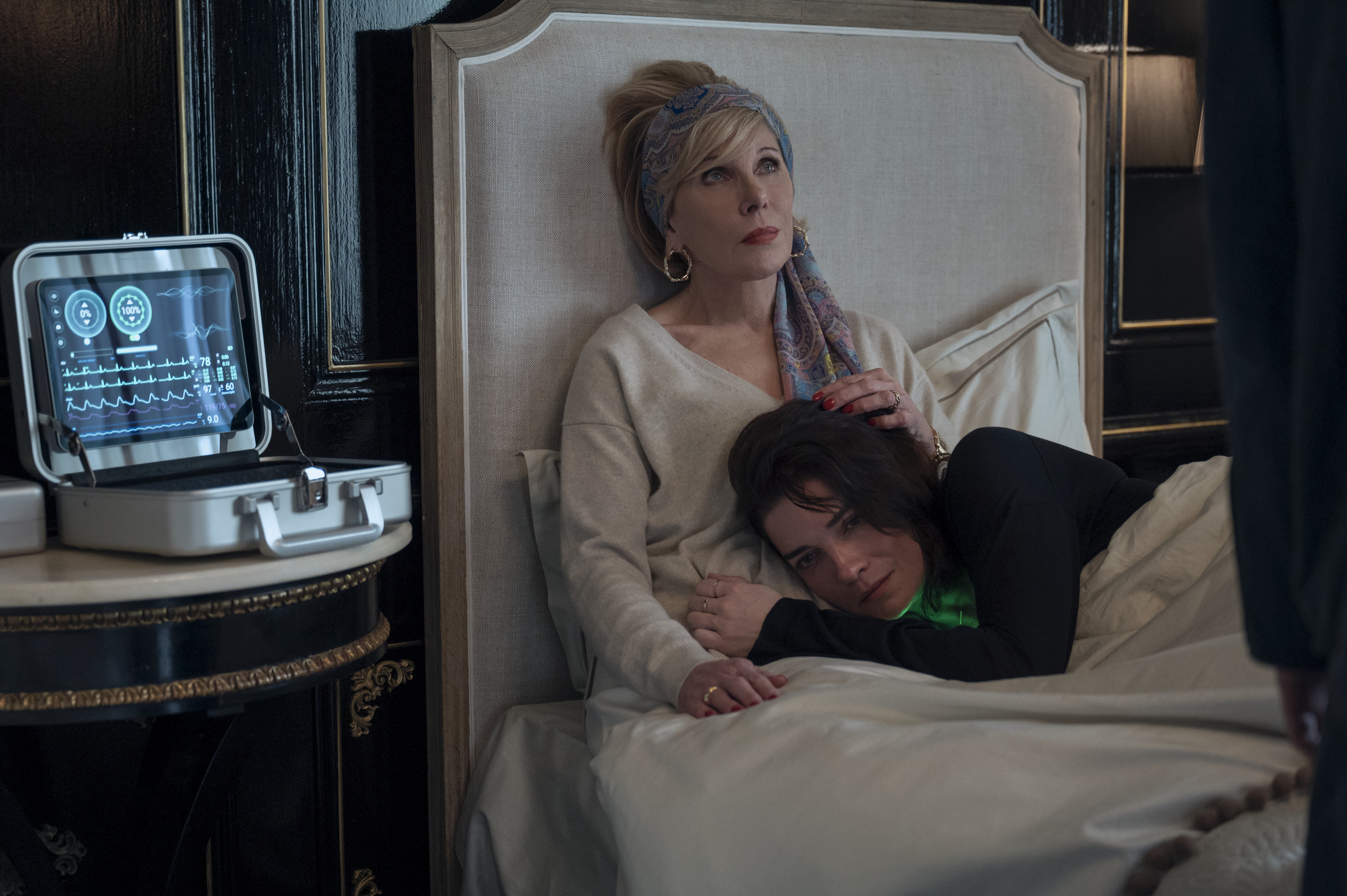 christine baranski in an upright hospital bed and annie murphy laying on her in nine perfect strangers season 2