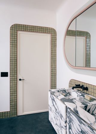 a bathroom with a tile trim around the door