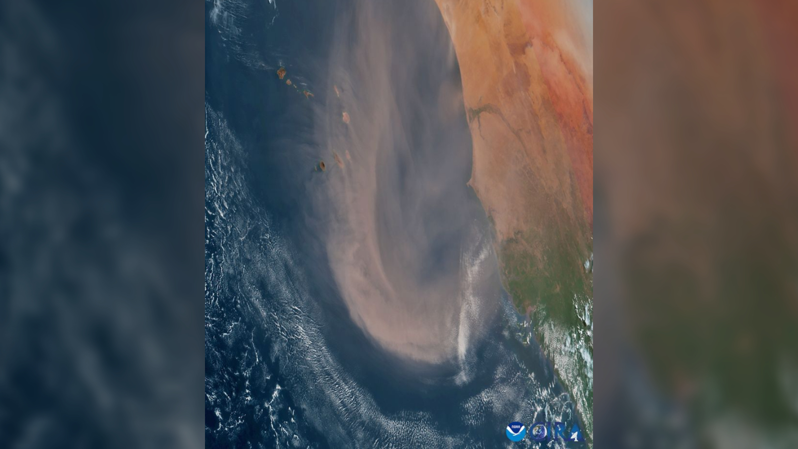 A satellite photo of a large orange dust cloud over the ocean along the coast of West Africa