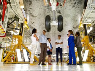 President Barack Obama, First Lady Michelle Obama, daughters Malia, left, Sasha, and Mrs. Obama's mother, Marian Robinson, walk under the landing gear of the space shuttle Atlantis. Astronaut Janet Kavandi and United Space Alliance project lead for thermal protection systems Terry White conduct the tour of Kennedy Space Center in Cape Canaveral, Fla., Friday, April 29, 2011.