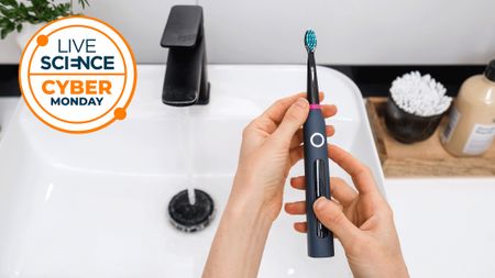 an electric toothbrush being held over a sink