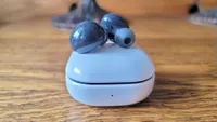 The Samsung Galaxy Buds 2 on top of their charging case, on a table
