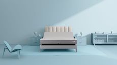 Sleep Number c2 mattress on a light grey bed with fluted headboard, against a pale blue wall. The nightstands, chair, cabinet, and accessories are all the same shade of blue.