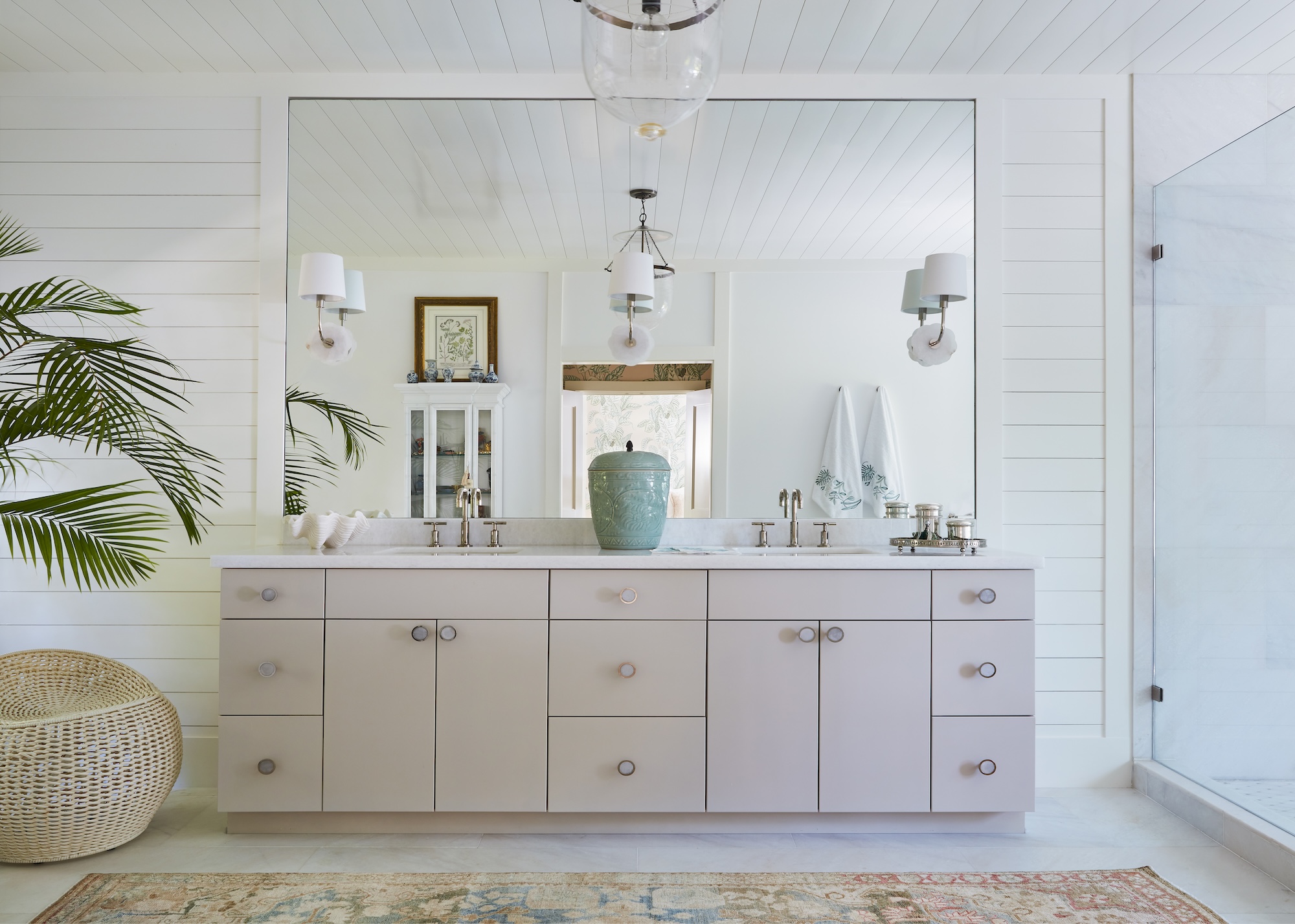 A double bathroom vanity basin in blush pink with a huge oversized mirror and rug