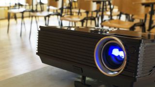 Projector with classroom desks in background