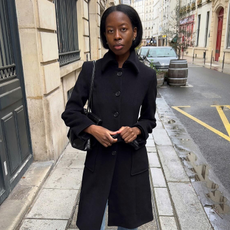Influencer wearing black car coat and straight leg denim on streets of Paris.