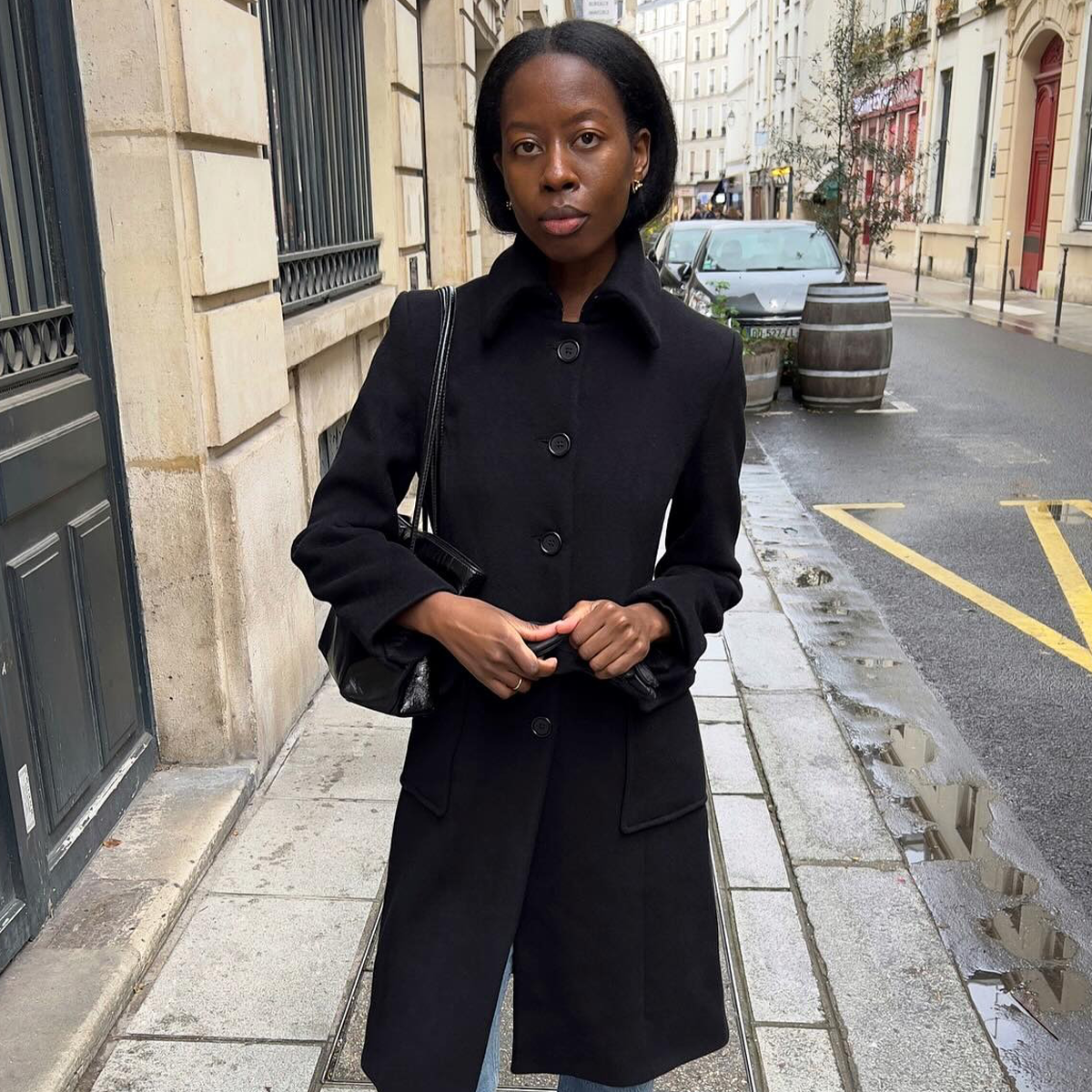 Influencer wearing black car coat and straight leg denim on streets of Paris.