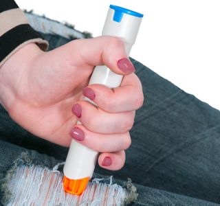 A woman injects medicine into her leg.