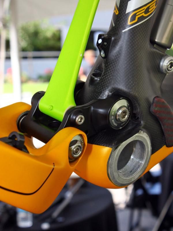 The rear derailleur housing exits the main frame just ahead of the lower link pivot.