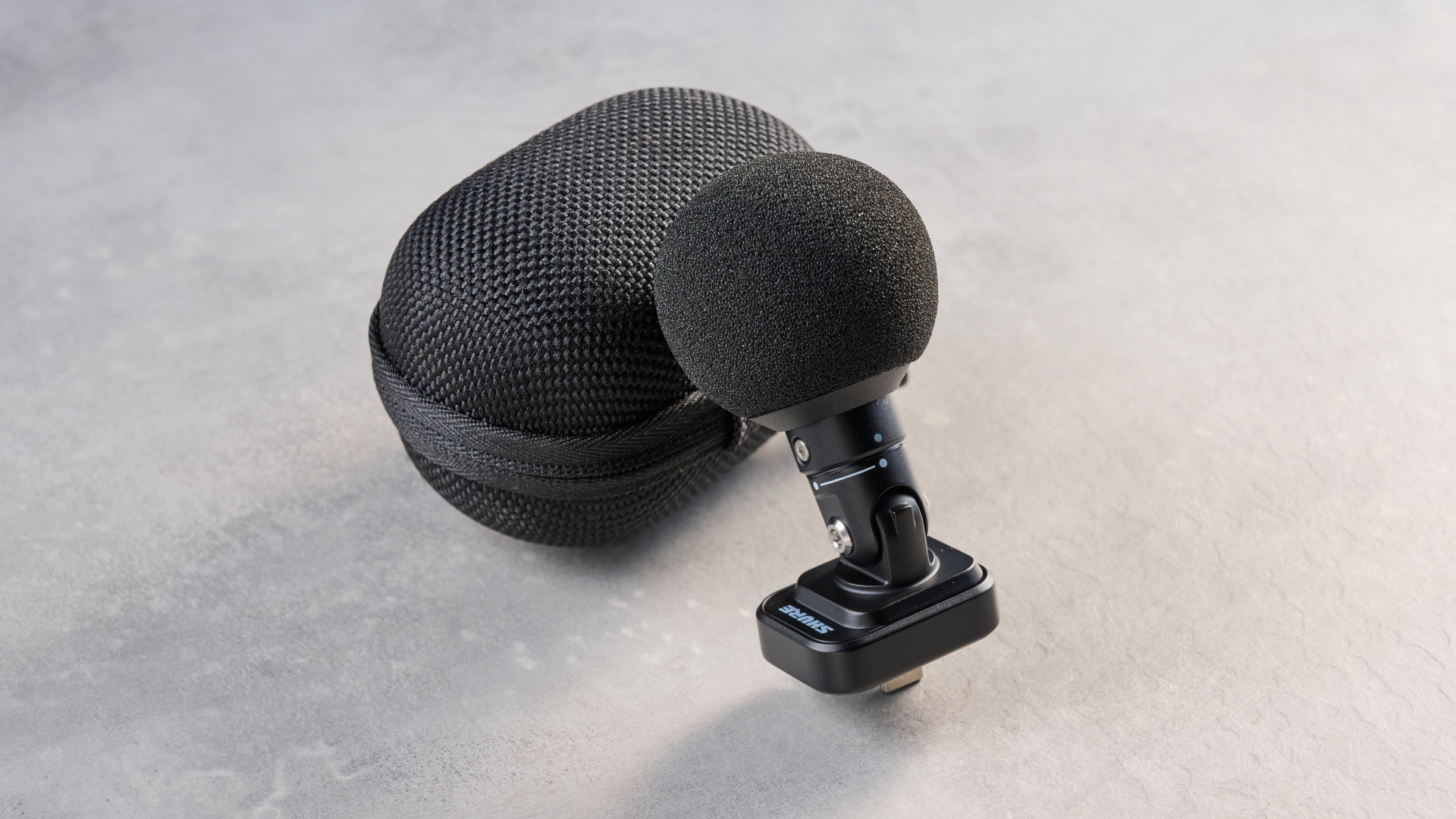 the shure mv88 usb-c microphone photographed against a blue tom's guide background and shown connected to a google pixel 10 pro