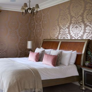 Luxe bedroom scheme featuring subtle metallic wallpaper in gold and blush tones