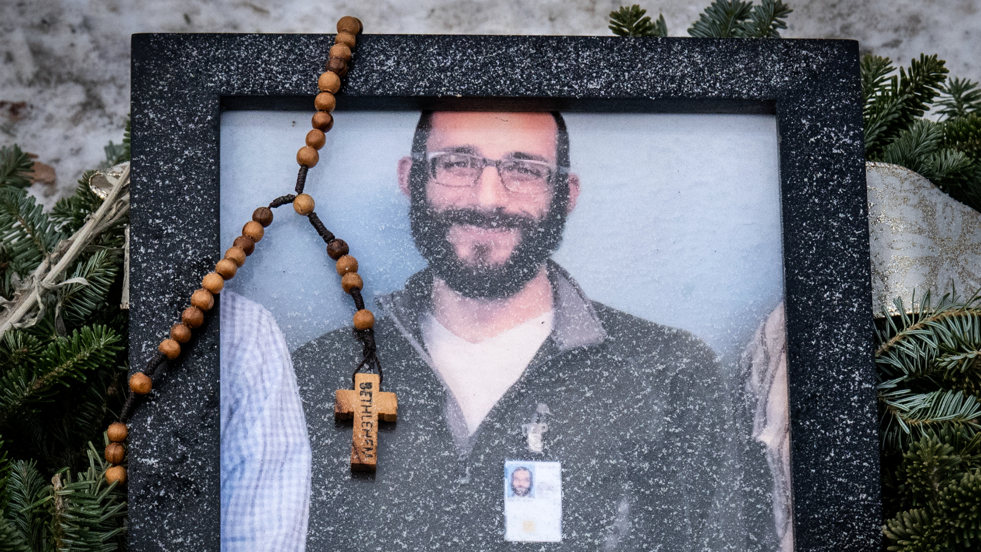 Photo of Alex Pretti, and ICE nurse shot by Border Patrol agents, adorned with a rosary at makeshift memorial
