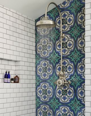 blue and green decorative tiles in a running shower