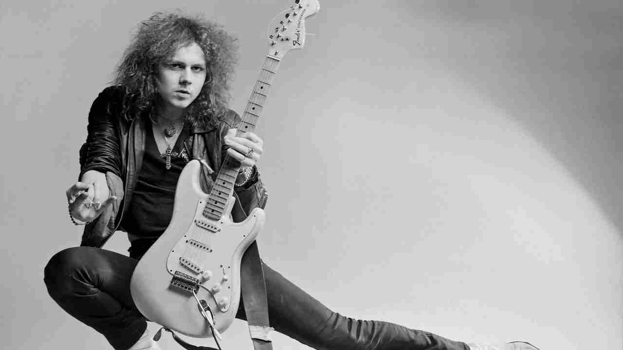 Yngwie Malmsteen posing for a photograph with a guitar