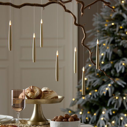 LED floating candles in gold dangling over a festive tablescape