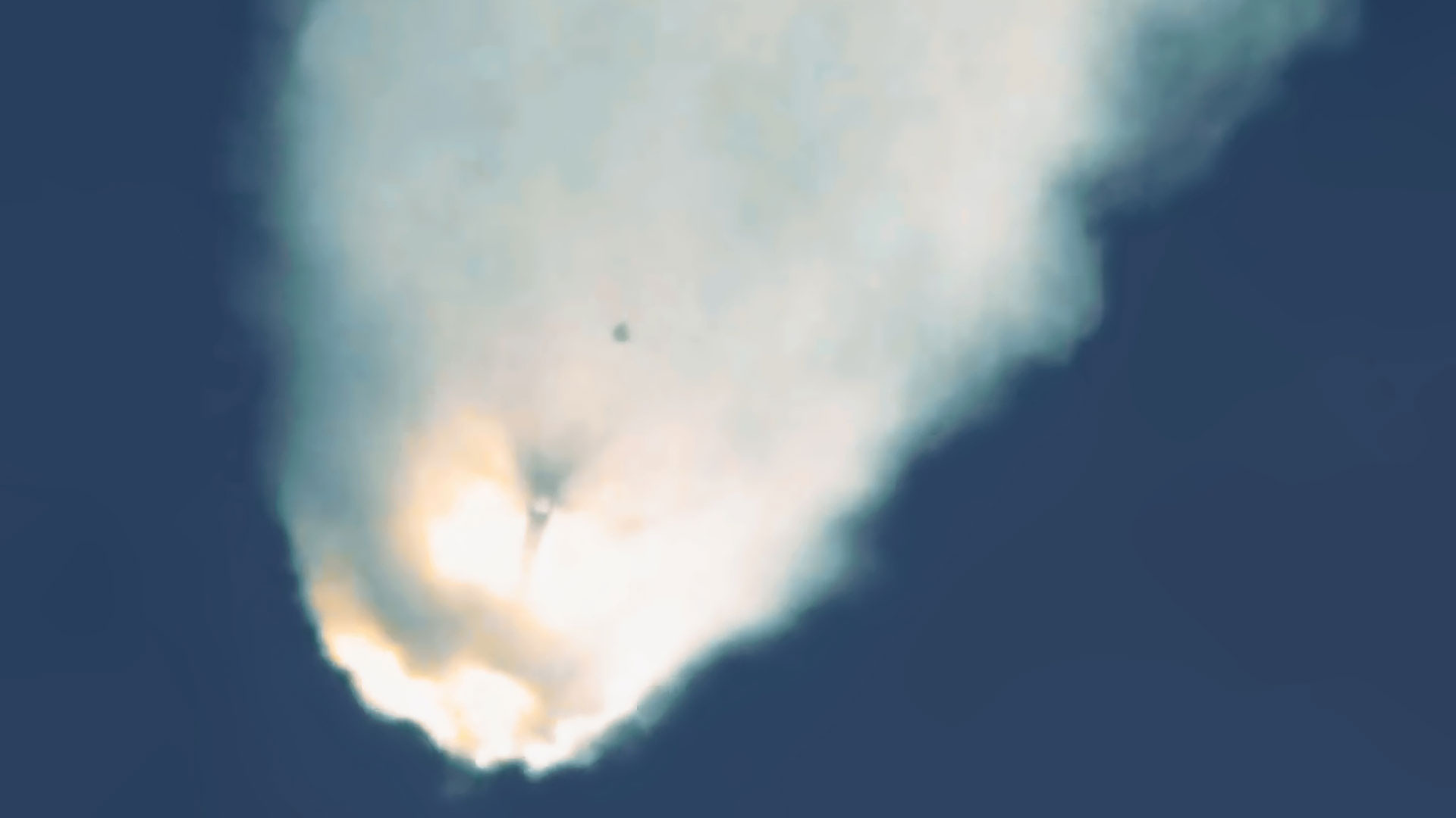 the white and orange plume from an mid-air explosion of a rocket