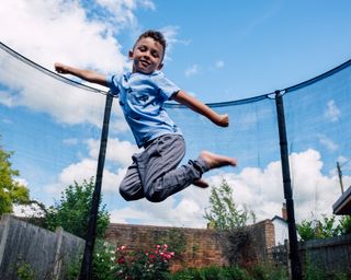 Young boy jumping in the air on a trampoline
