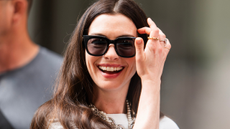 Anne Hathaway on set for The Devil Wears Prada 2 wearing Coach satchel bag and white outfit