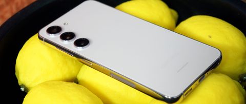 The Samsung Galaxy S23 Plus in white, laid face down on a bowl of lemons