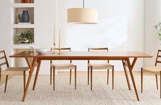 Modern dining room with large wooden rectangular dining table, four matching wooden dining chairs positioned around, light wood flooring