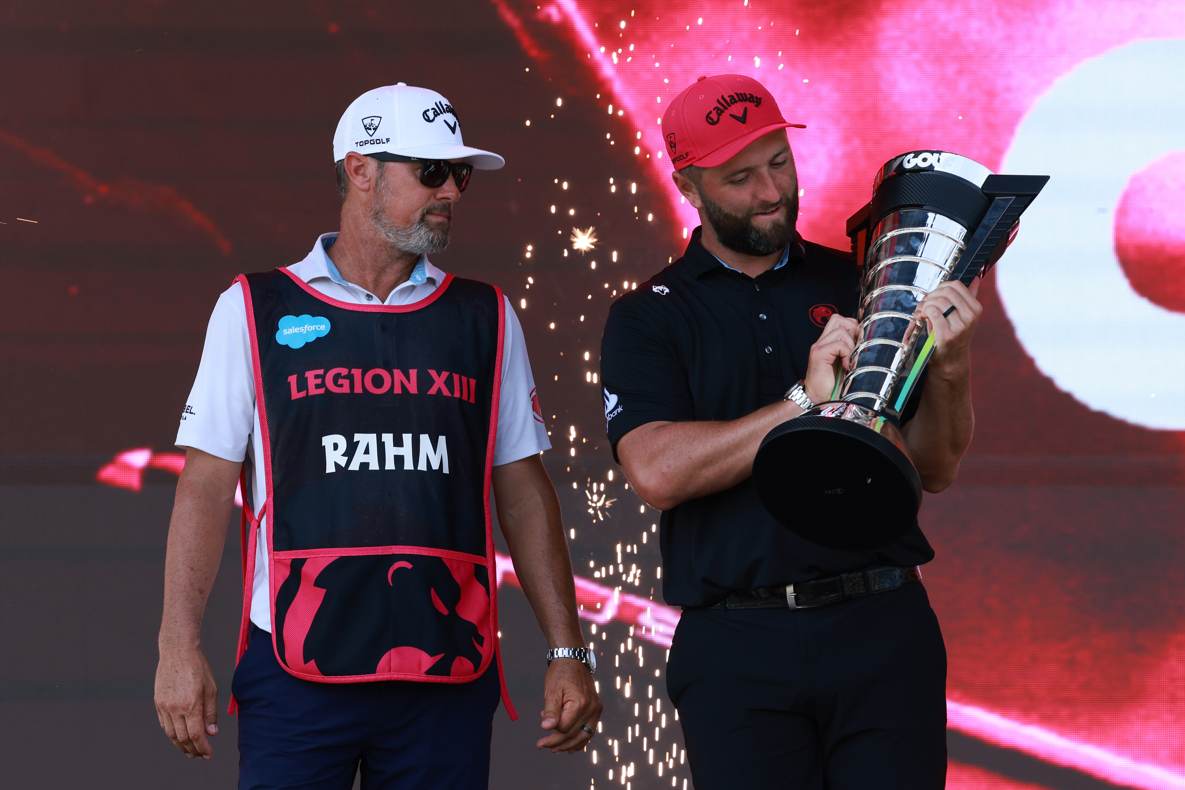 Jon Rahm poses with the LIV Golf individual title alongside his caddie
