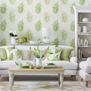 living room with white sofa and leafy wallpaper