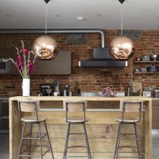 kitchen room with exposed brick walls and kitchen chimney