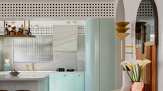 an open plan kitchen with an AC system hidden behind a perforated surface 