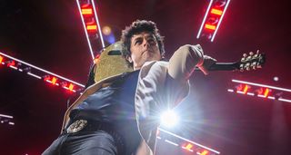 Billie Joe Armstrong plays his Gibson Les Paul Jr behind his head onstage in Chicago