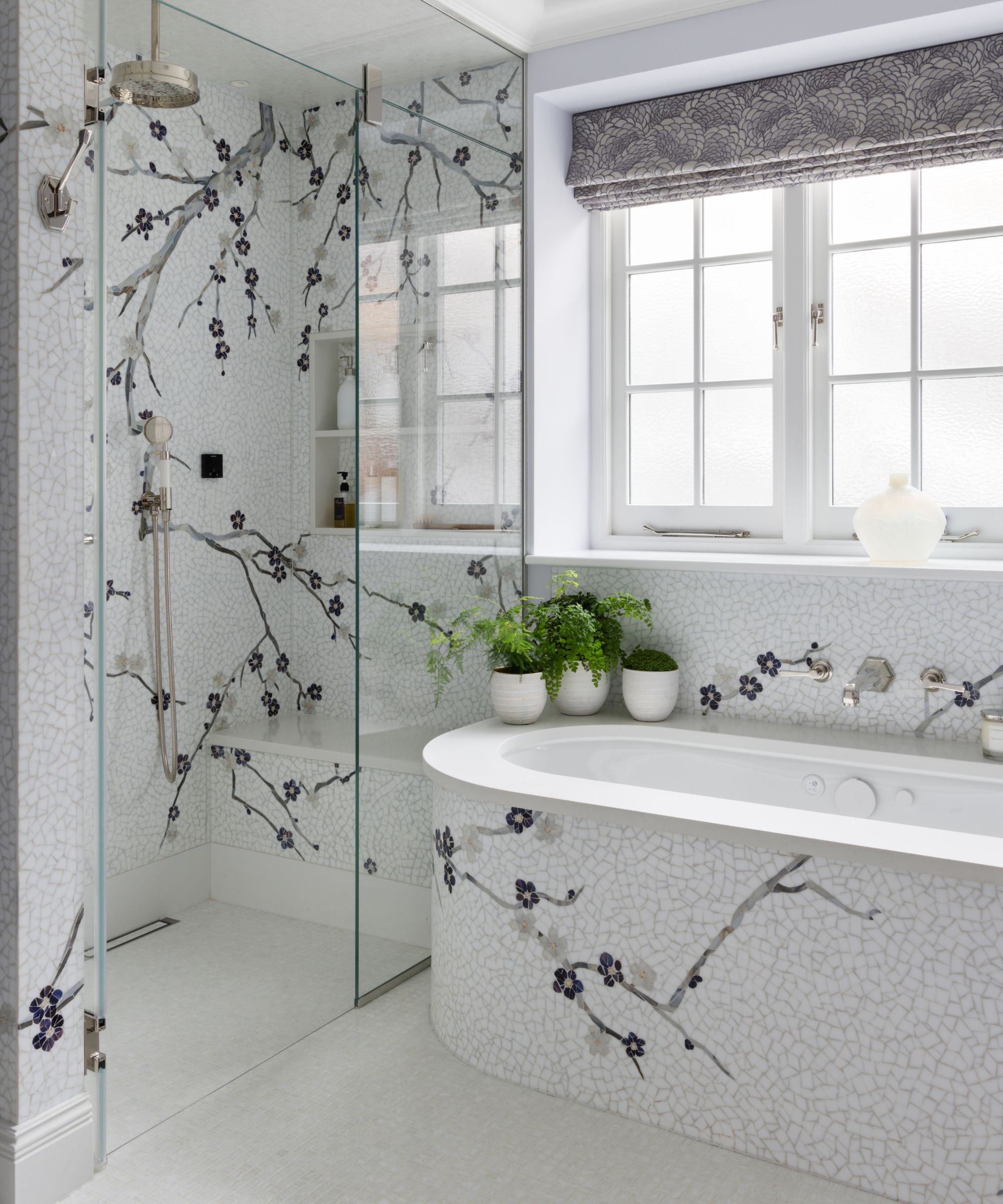 A neutral bathroom with a tile mural on the walls and bath