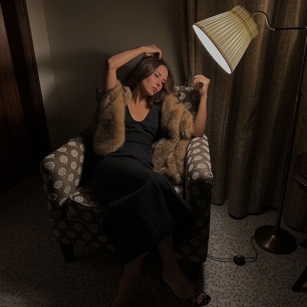 An image of influencer @deborabrosa sitting on a luxurious armchair