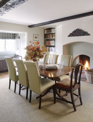 Dining room with wooden table and fire lit in fireplace