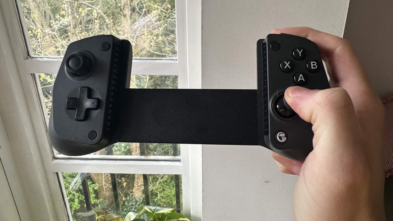 A reviewer holding the GameSir X5s in their right hand