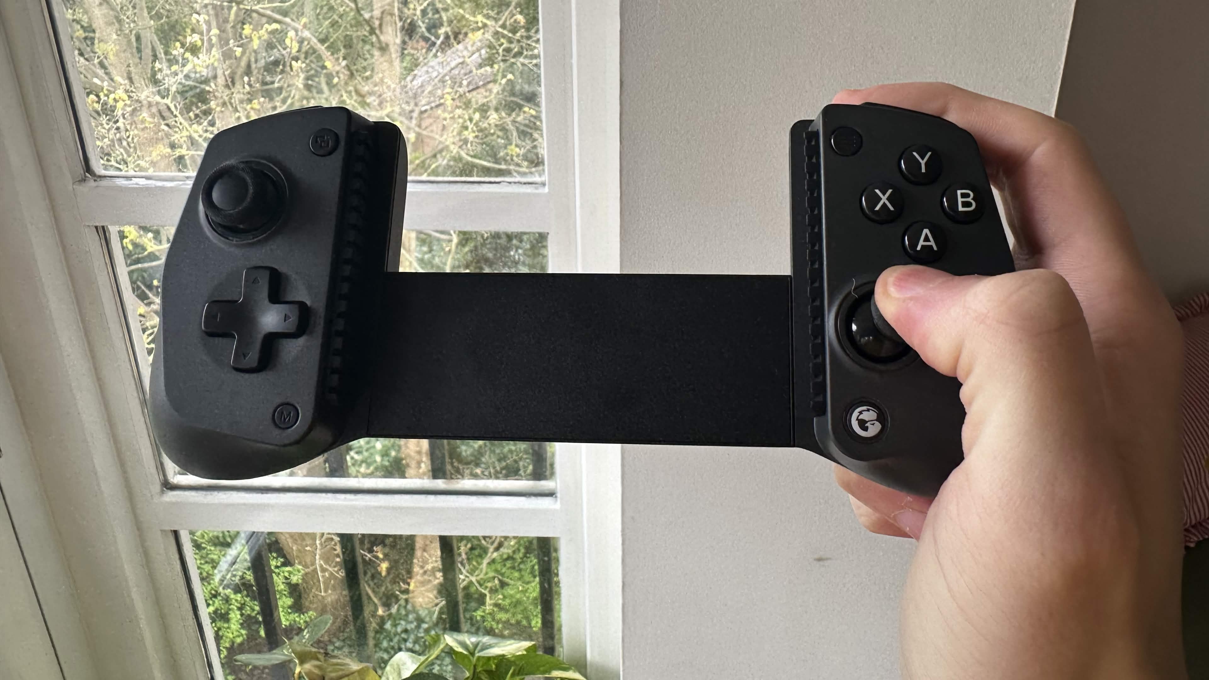 A reviewer holding the GameSir X5s in their right hand