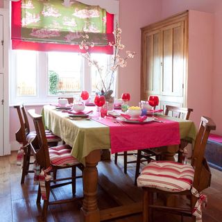 dining room with dining table chairs and powder pink walls