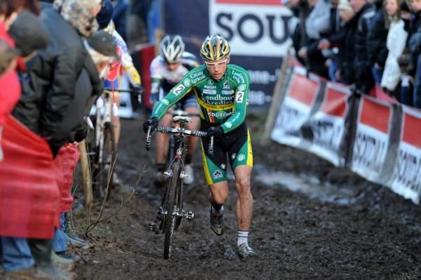 Sven Nys runs his bike through a sector of mud.