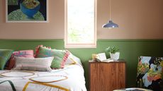 bedroom with plaster pink and green walls, colorful bedding, wooden nightstand