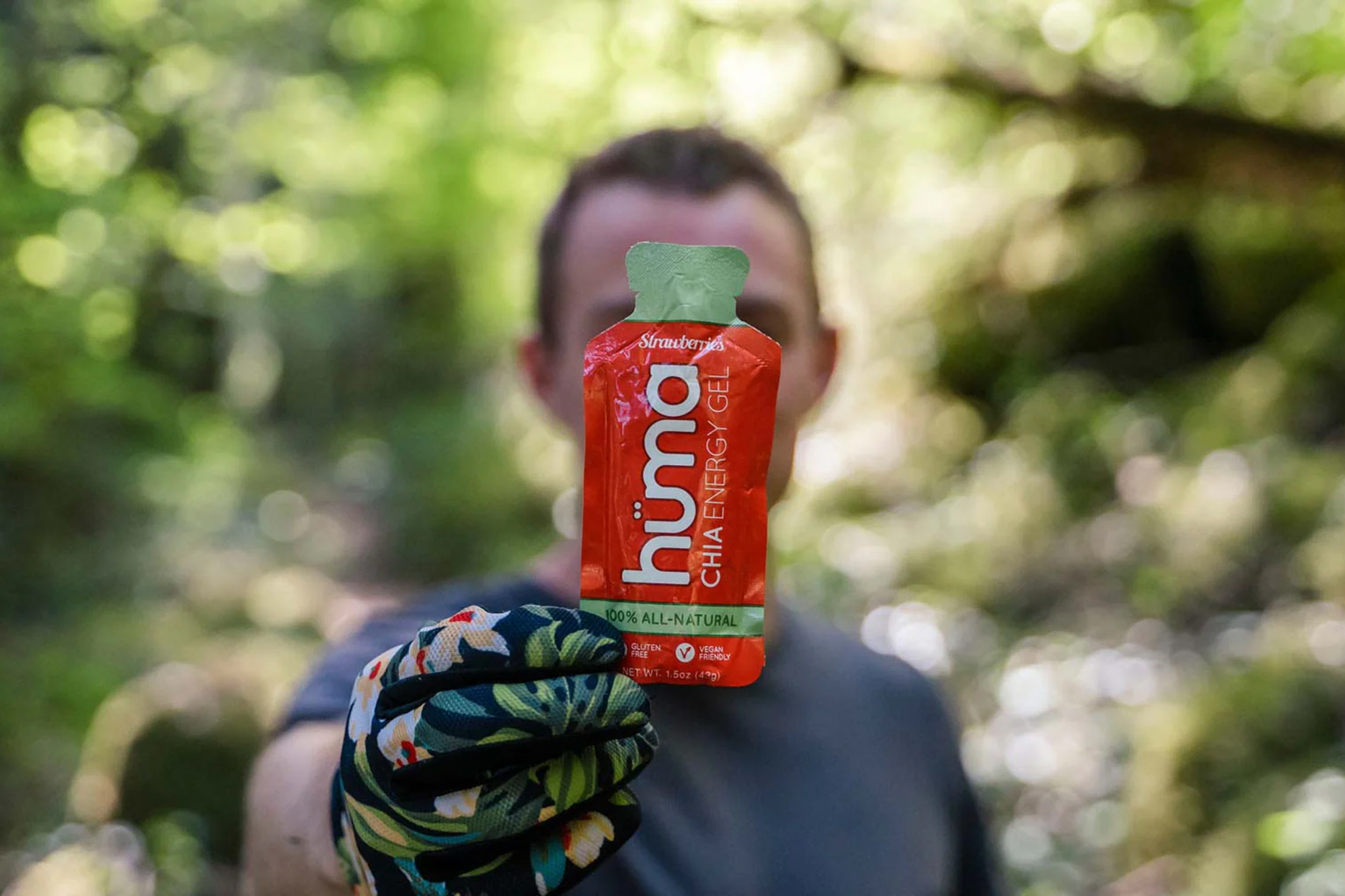 Hüma Chia energy gel being held up to cover a cyclists face