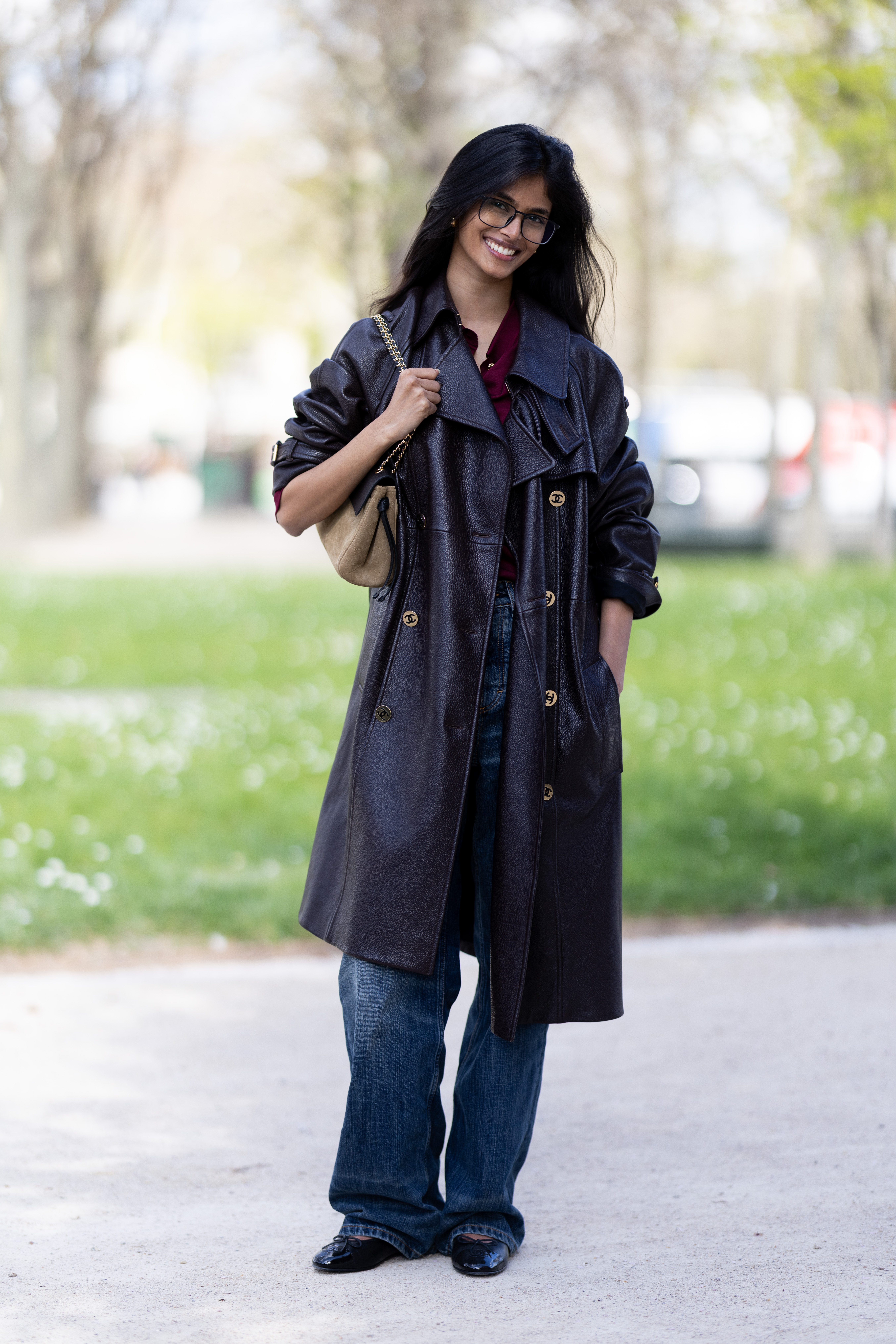 PARIS, FRANCE - MARCH 09: Bhavitha Mandava wears a red shirt, brown leather trench coat, blue jeans, beige suede bag outside Gabriela Hearst show during Day Eight of Paris Fashion Week - Womenswear Fall/Winter 2026/2027 on March 09, 2026 in Paris, France. (Photo by Valentina Frugiuele/Getty Images)