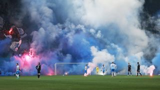 Fans of Universitatea Craiova throw smoke bombs on the pitch during the game between Universitatea Craiova and FCU Craiova 1948 in February 2022.