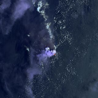 Bright purple clouds rise above Nishinoshima on July 4, representing steam from the volcano or from lava vaporizing seawater.