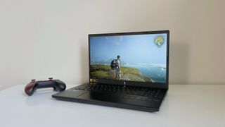 The Acer Nitro V 15 running Once Human on a white table with a game controller