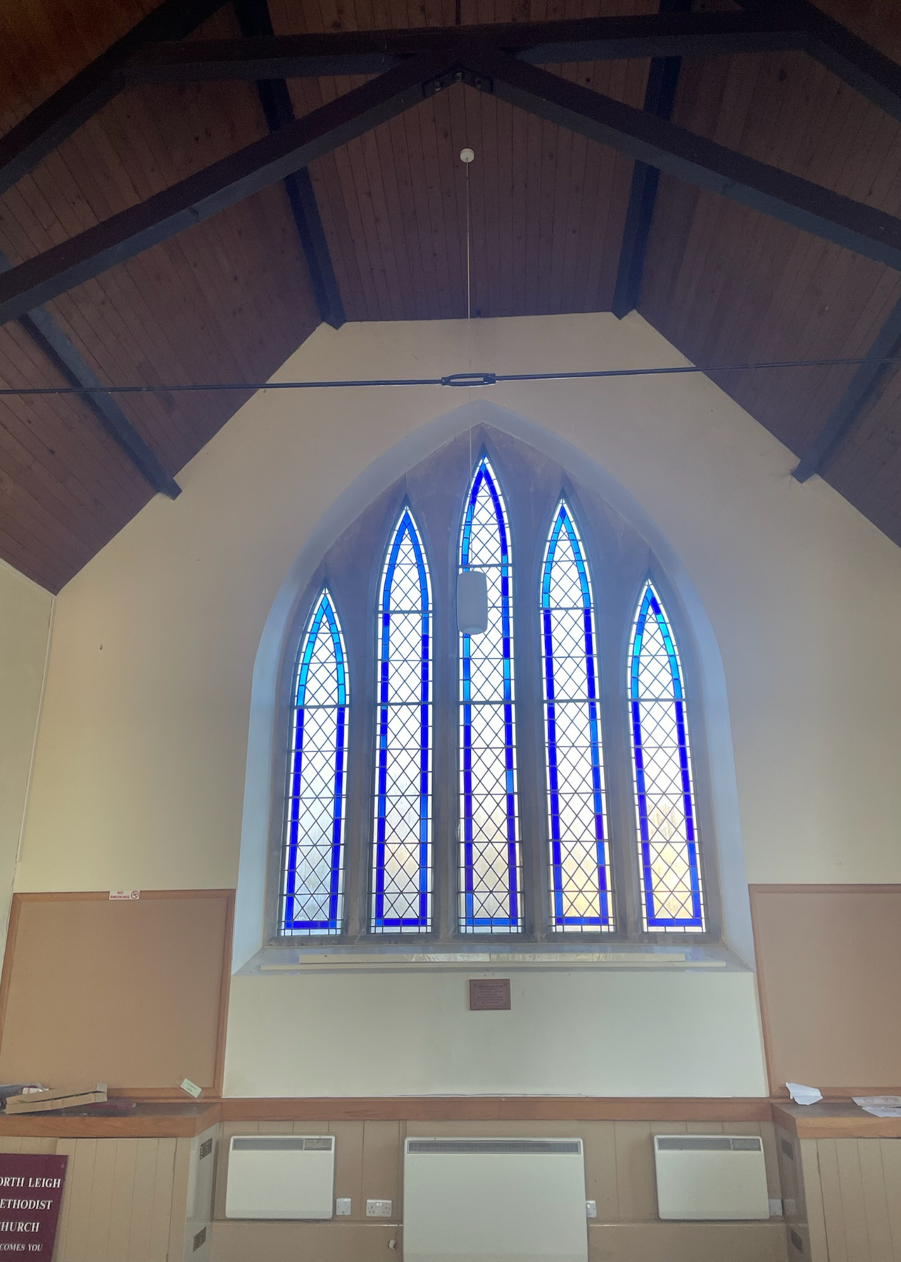 stained glass window beneath a wooden vaulted ceiling