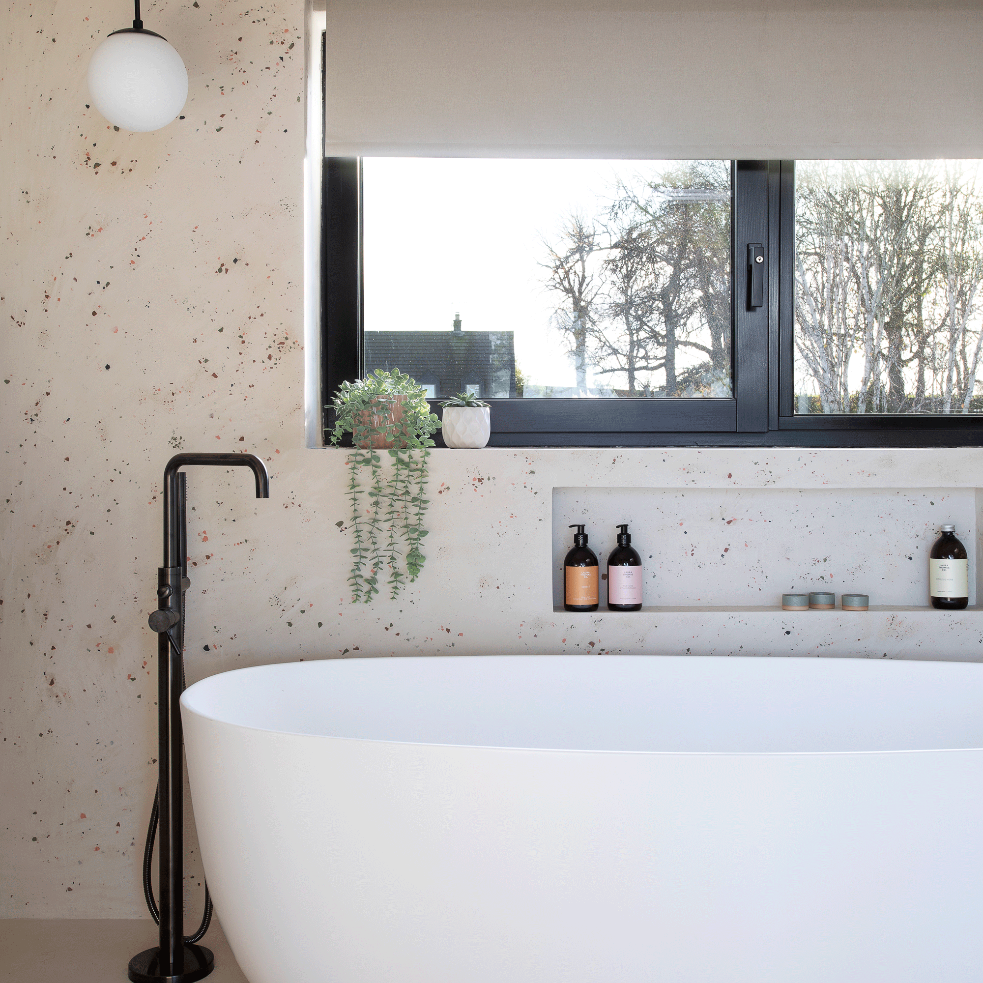 a bathroom with a modern bathtub with a black mixer