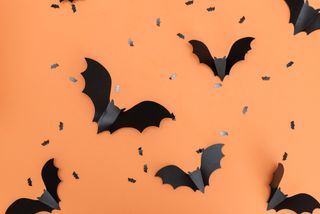 An orange background with little bat table decorations.