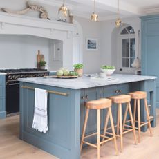 blue shaker-style kitchen with blonde wooden floor