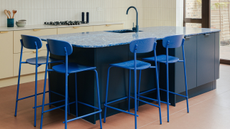 Modern kitchen with blue countertops, matching blue stools, and blue taps